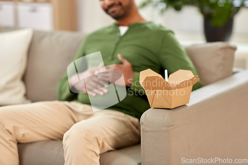 Image of cup of takeaway food over man at home