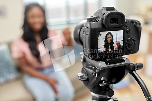 Image of female blogger with camera video blogging at home