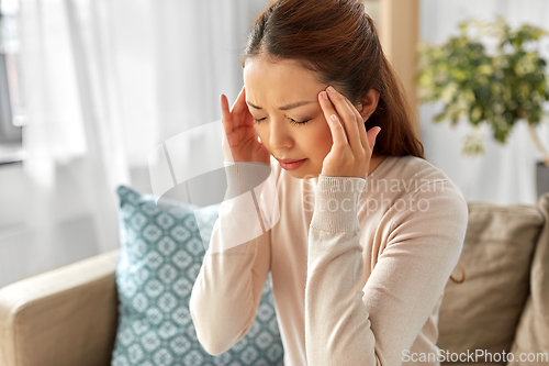 Image of sick asian woman having headache at home