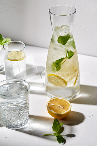 Image of glasses with lemon water and peppermint on table