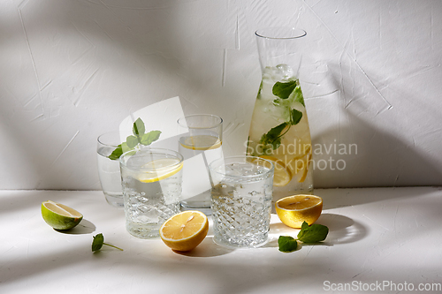 Image of glasses with lemon water and peppermint on table