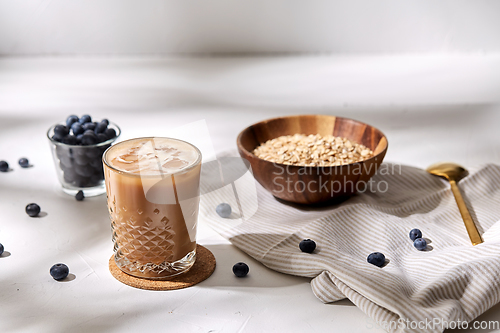 Image of glass of ice coffee, oatmeal and blueberries