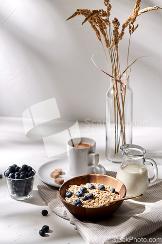 Image of oatmeal with blueberries, milk and cup of coffee