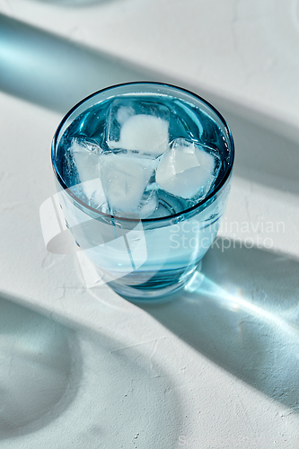 Image of blue glass of cold water with ice cubes