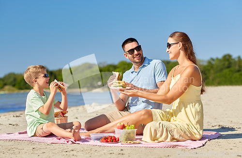 Image of happy family having picnic on summer beach