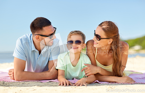Image of happy family lying on summer beach