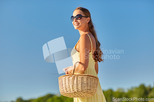 Image of happy smiling woman with picnic basket in summer