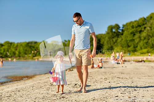 Image of happy father walking with little daughter on beach