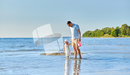 Image of happy father walking with little daughter on beach