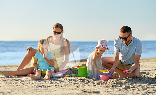 Image of happy family with children playing on summer beach