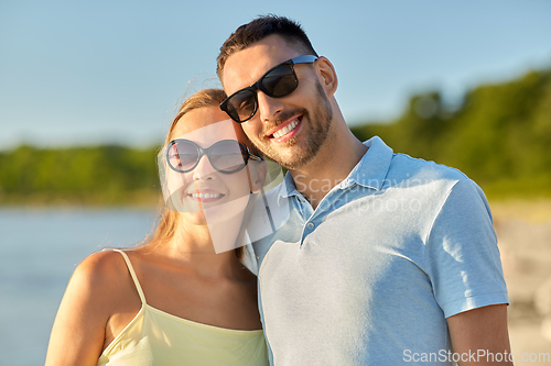 Image of happy couple hugging on summer beach