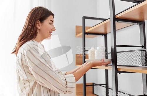 Image of woman decorating home with candles