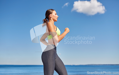 Image of young woman running at seaside