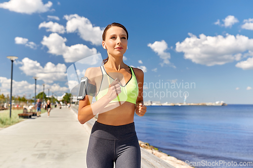 Image of woman with earphones and smartphone running