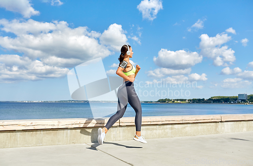 Image of woman with headphones and smartphone running