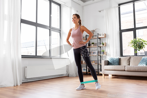 Image of woman exercising with resistance band at home