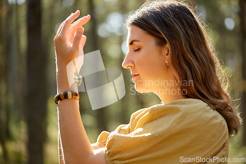 Image of woman or witch performing magic ritual in forest