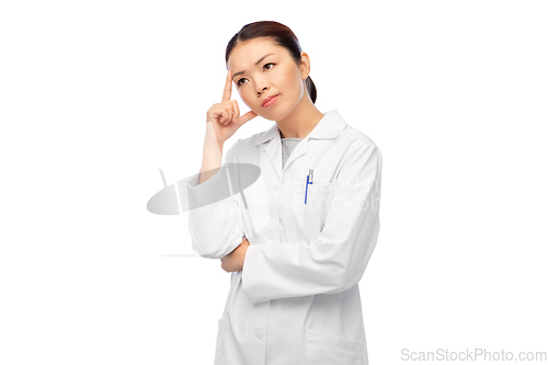 Image of thinking asian female doctor in white coat