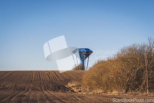 Image of Blue water tower om a dry field