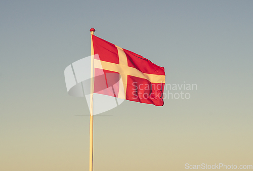 Image of Danish flag at dawn waving in the wind