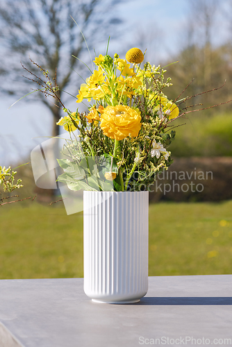 Image of White vase with yellow wildflowers