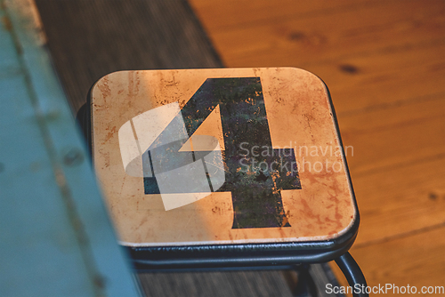 Image of The number 4 on a small chair in a room