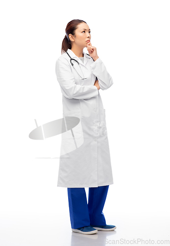 Image of thinking asian female doctor in white coat
