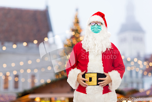 Image of man in costume of santa claus wearing medical mask