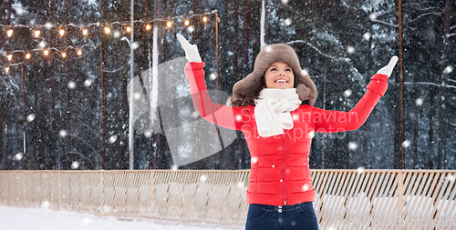 Image of happy woman in winter fur hat at ice rink