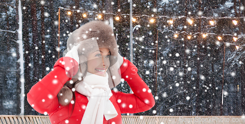 Image of smiling woman in winter hat over ice skating rink