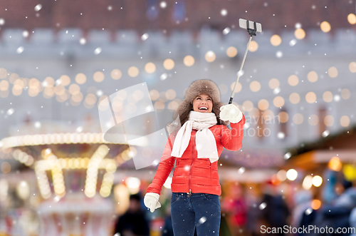 Image of happy woman taking selfie over christmas market