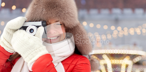 Image of happy woman with film camera over christmas market