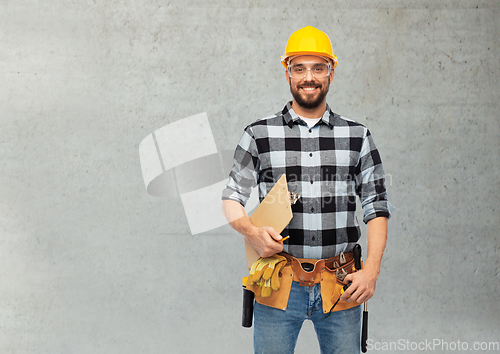 Image of male worker or builder in helmet with clipboard