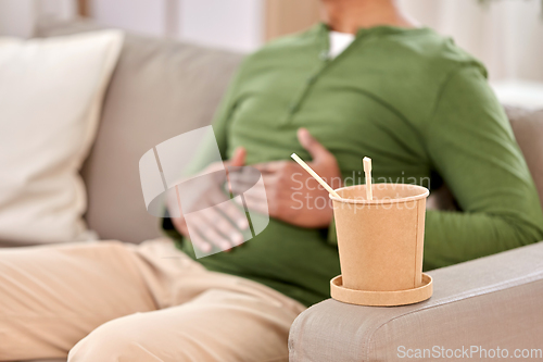 Image of cup of takeaway food over man at home