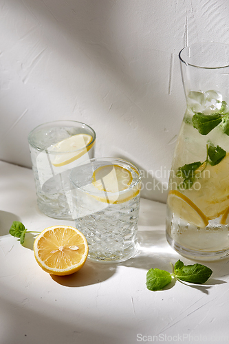 Image of glasses with lemon water and peppermint on table
