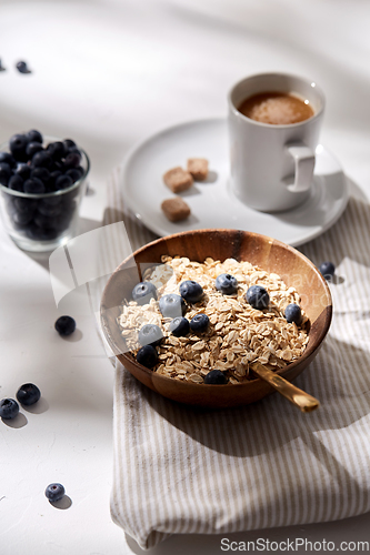 Image of oatmeal with blueberries, spoon and cup of coffee