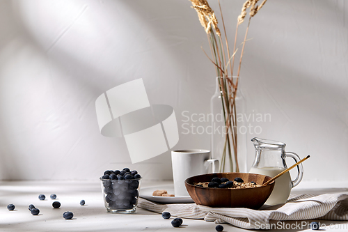 Image of oatmeal with blueberries, milk and cup of coffee