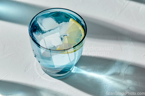 Image of blue glass of water with lemon and ice