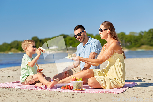 Image of happy family having picnic on summer beach
