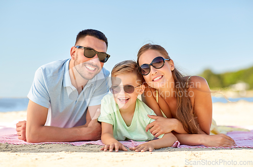 Image of happy family lying on summer beach