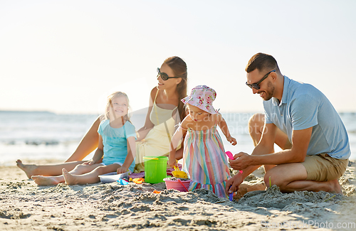 Image of happy family with children playing on summer beach