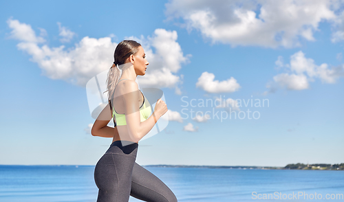 Image of young woman running at seaside