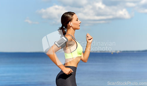 Image of woman with earphones and smartphone running