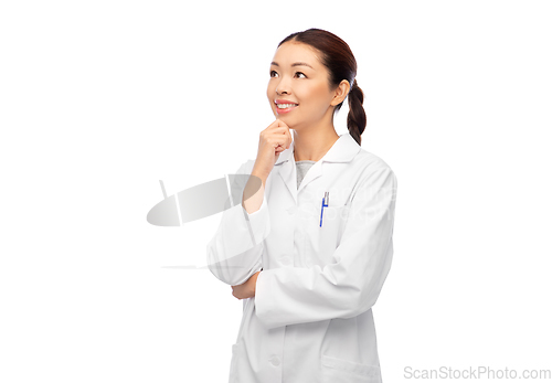 Image of thinking asian female doctor in white coat