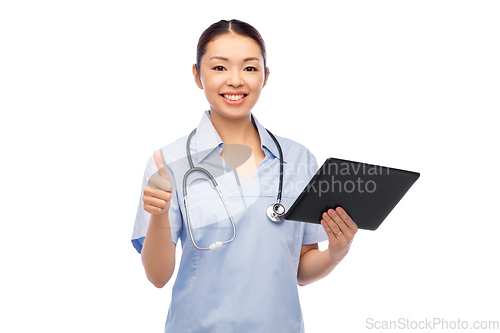 Image of asian female nurse with tablet pc shows thumbs up