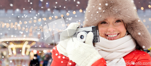 Image of happy woman with film camera over christmas market
