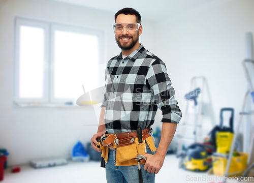 Image of happy male worker or builder with tool belt