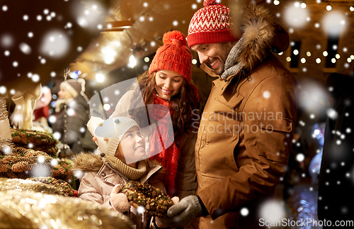 Image of happy family buing wreath at christmas market