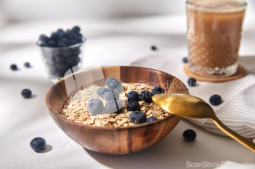 Image of oatmeal with blueberries, spoon and coffee