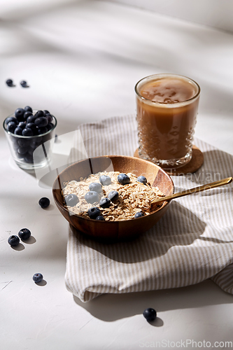 Image of oatmeal with blueberries, spoon and coffee